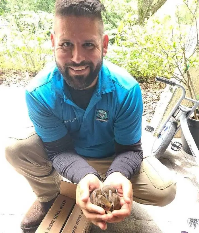 Pro Wildlife Removal technician holding a small animal in his hands